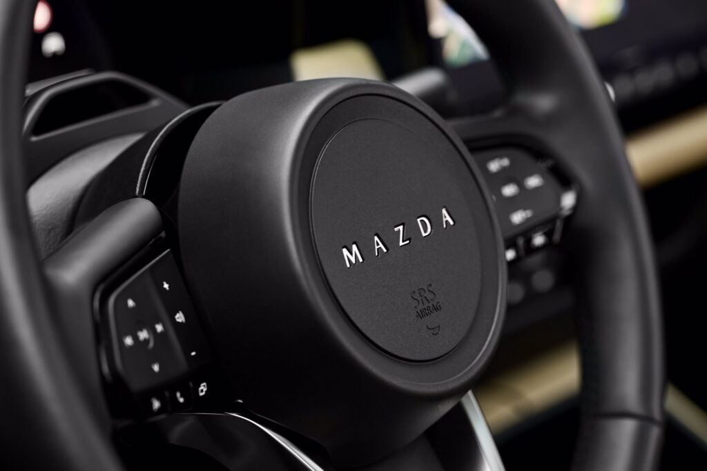 Samochód Mazda CX-5 (zbliżenie na logo marki na kierownicy)